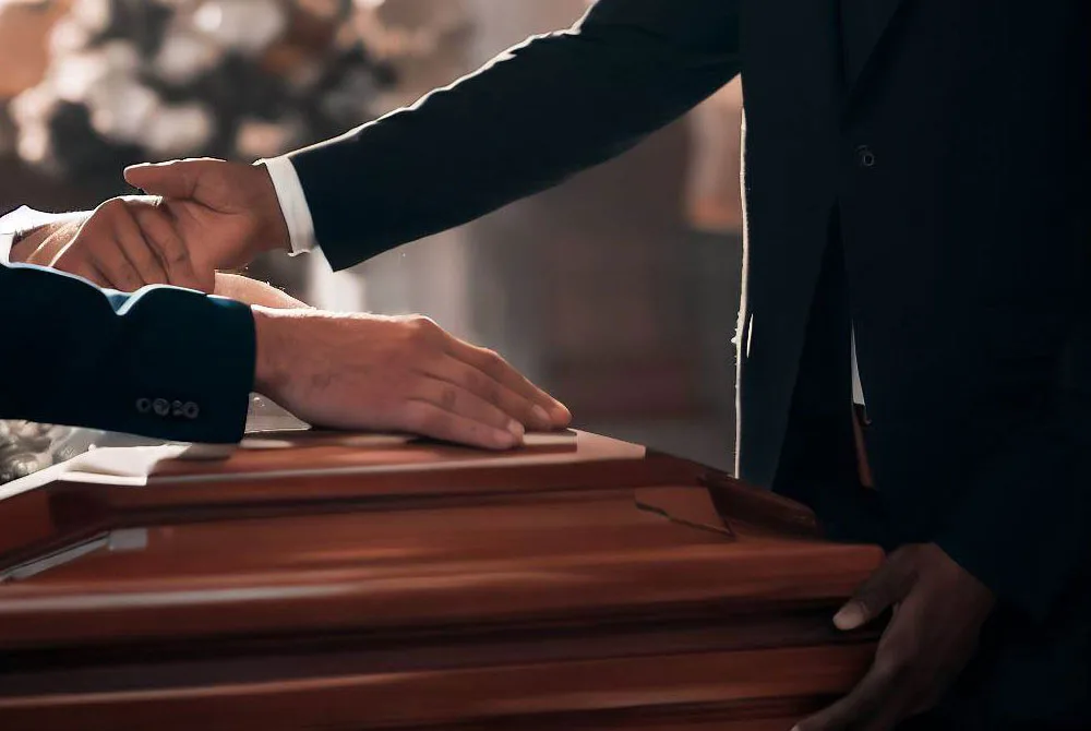 Una persona dando el pésame a otra en un funeral